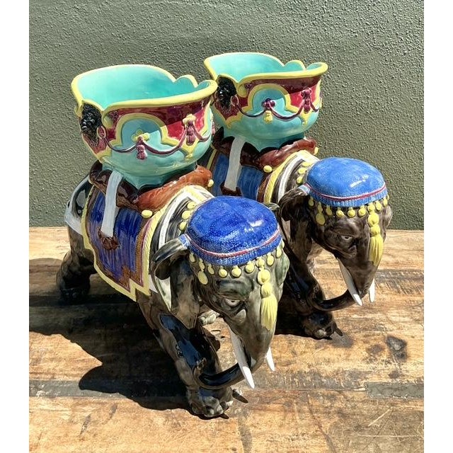 This striking pair of vintage elephant planters is a masterclass in Hollywood Regency glamour and maximalist design....