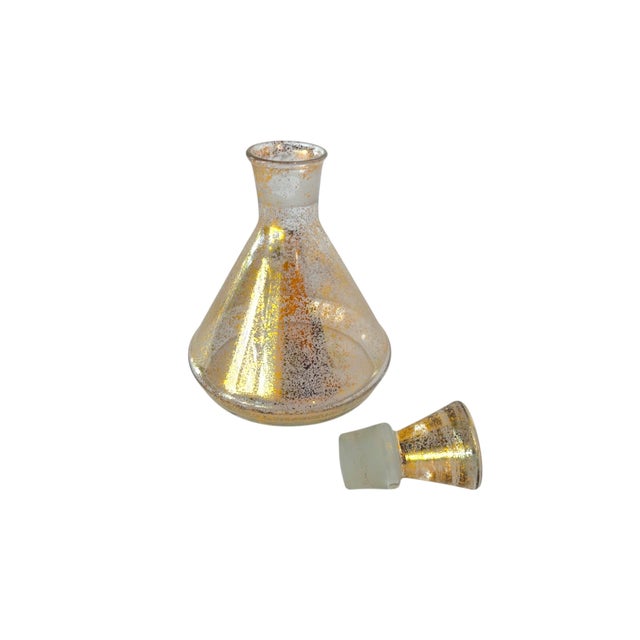 A set of nine midcentury shot glasses and decanter decorated with a gold flecked pattern in the manner of Dorothy Thorpe....