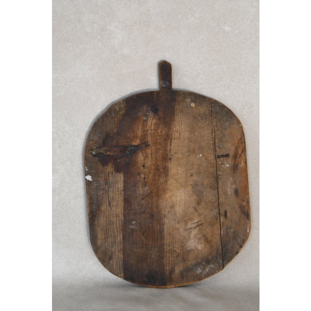 This early 20th Century antique European breadboards was hand-carved from solid wood. Perfect for layering on a kitchen...