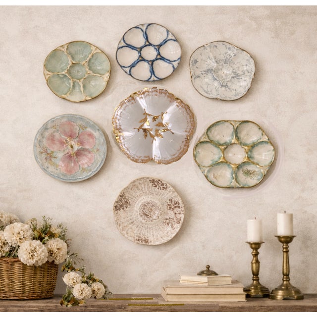 This luxury retail porcelain plate with deeply sculpted six-well shell forms with a central sauce well, enhanced by hand-...