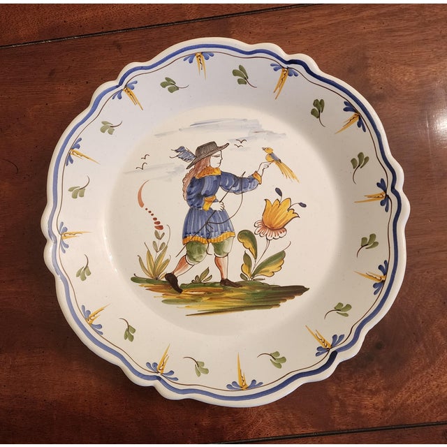 18th Century French Nevers faience plate. Features a whimsical hand-painted polychrome countryside scene depicting a...