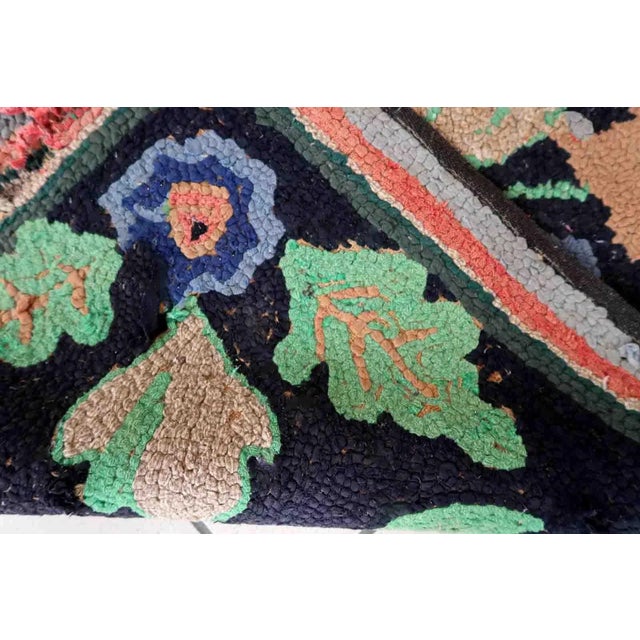 Handmade antique American Hooked rug in floral design and black background. The rug is from the beginning of 20th century....