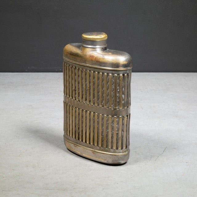 ABOUT An Art Deco brass plate over chrome caged metal hip flask with screw top lid and glass interior. Designed to be slim...