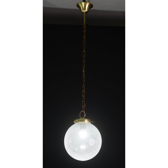 Elegant Italian mid-century modern pendant light dating from the 1970s, featuring a striking optic spiral glass globe...