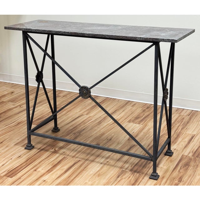 Stunning vintage stone top wrought iron console table. Features heavy architectural style frame with unique detail to...