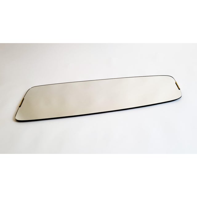 Frameless bevelled wall mirror, new old stock, Austria, 1950s A tall, tapered rectangular mirror with softly rounded...