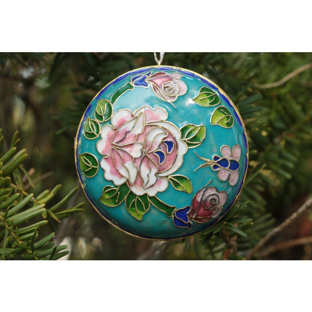 This large double-sided champlevé cloisonné Christmas ornament has raised floral detail featuring three blooms and buds on...