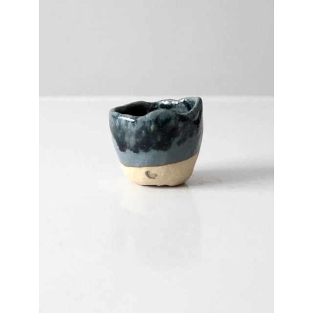 This is a vintage studio pottery vessel. Hand-crafted, the wabi sabi pottery bowl has a dipped blue glaze with rustic slab...