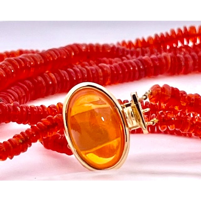 This striking multi-strand necklace features rows of rich red-orange rondelle beads, faceted and stacked closely together...