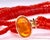 This striking multi-strand necklace features rows of rich red-orange rondelle beads, faceted and stacked closely together...