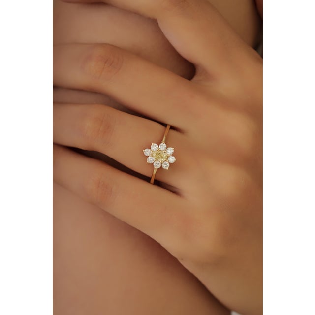 This cluster ring showcases a 0.76 carat diamond set in 14K yellow gold. The pear-shaped center diamond measuring 5.2 x...