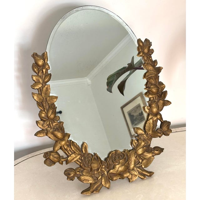 1930s tabletop mirror surrounded by gilt wood roses with an easel back. Both practical and decorative. Please see...