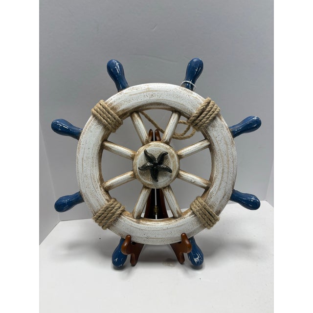 Bring relaxed coastal charm to your space with this decorative nautical ship’s wheel wall hanging. Finished in distressed...