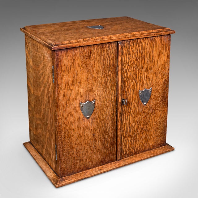 This is an antique Cambridge doctor's smoking cabinet. An English, oak and cedar smoker's case, dating to the Edwardian...