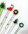 A festive collection of vintage Murano-style art glass swizzle sticks featuring whimsical sculptural motifs including...