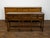 An English oak dresser base from the mid 19th century, with three drawers, scalloped apron and turned legs. Created in...