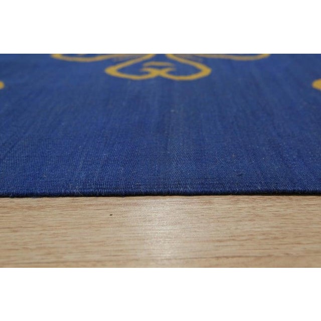 This hand woven wool rug features a traditional Kilim style construction with a primary blue color palette. Crafted in...