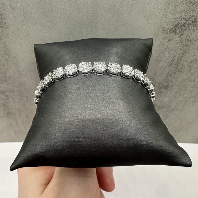 This stunning natural diamond tennis bracelet in sterling silver features 2 carats total weight of IJ, I quality round...