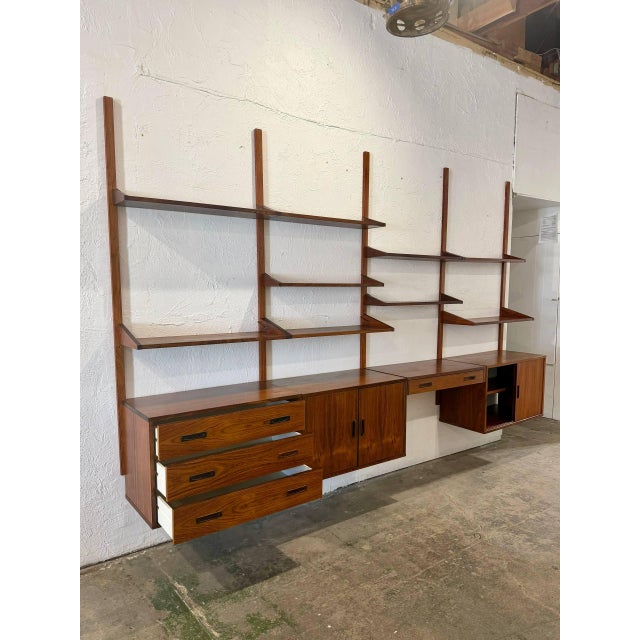 This four-bay modular wall unit offers versatile adjustable open shelving and lower storage compartments. The floating...
