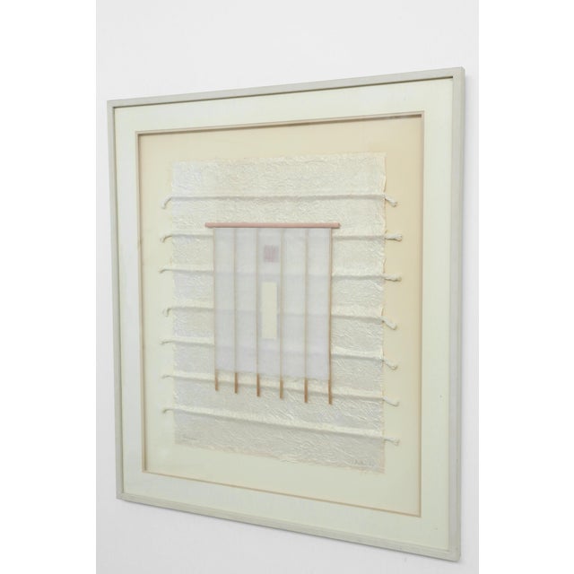Handmade paper, woven textile, cord, and wood elements are layered within a restrained geometric arrangement. Titled,...