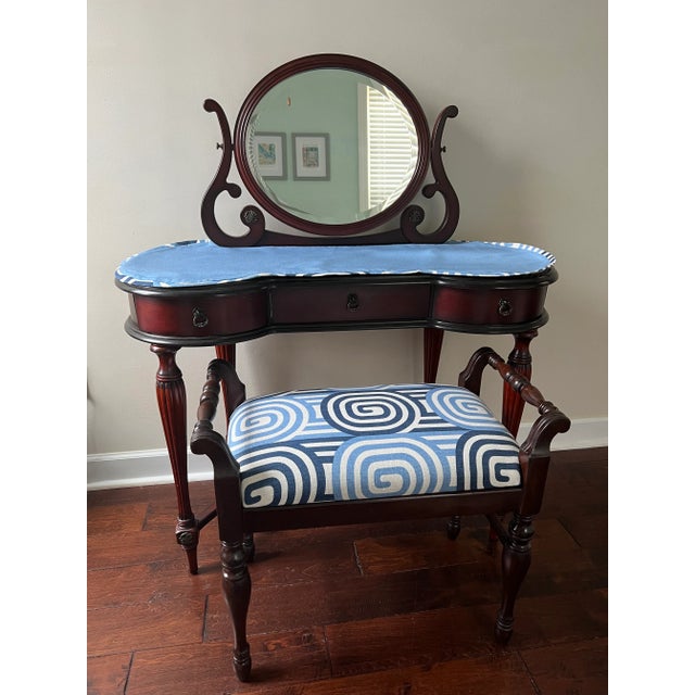 Lovely vintage mahogany mirror vanity table with an antique bench upholstered in Wavelength by Urban American. There is a...