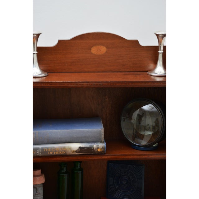 English edwardian mahogany bookcase of slim and narrow proportion, having a shaped and fan inlaid in upstand above five...