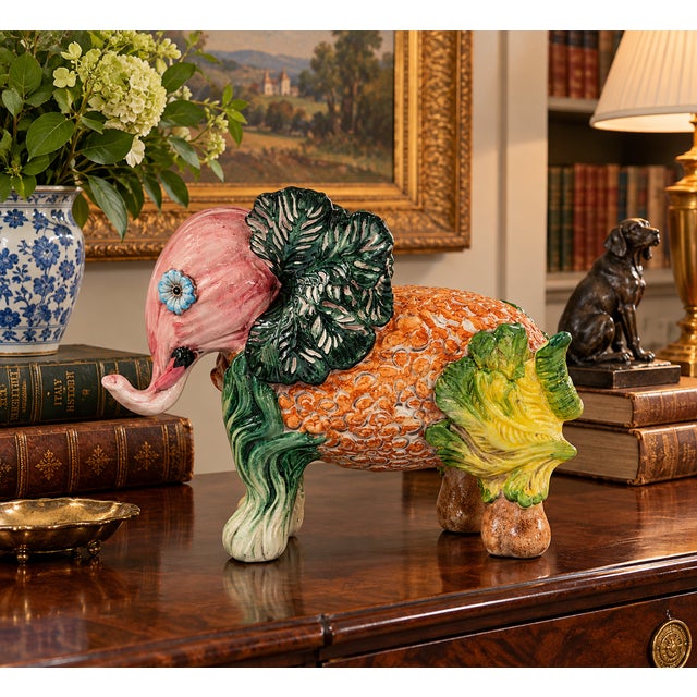 A vintage Italian hand-painted majolica elephant sculpture featuring an imaginative trompe l'oeil composition of fruits,...
