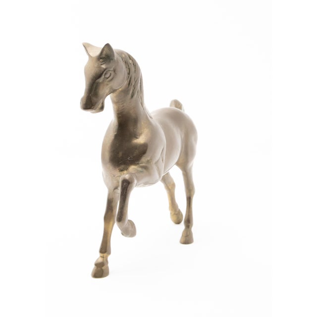 Solid brass standing horse figure. Patina is natural to the metal. The horse is depicted in mid stride. Battlefield...