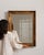 Carved giltwood mirror in Antique Gold. Its antique gold finish sets off rectangular molded gilt frame, warm patina, a...