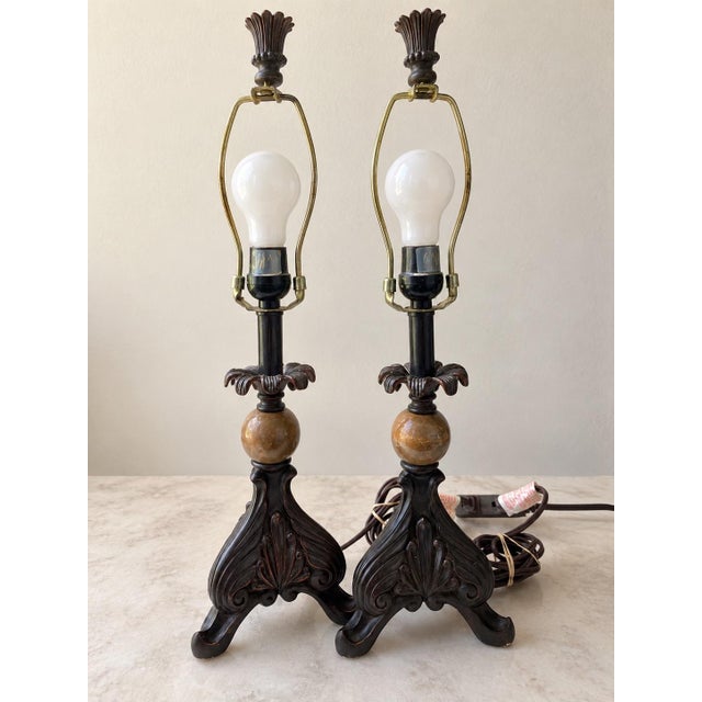 Elegant vintage pair of table lamps featuring highly ornate sculptural bases with flowing leaf and scroll motifs. Each...