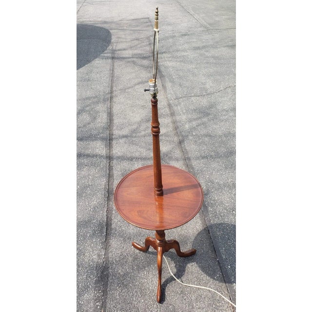 A Mid-Century Mahogany Tripod Snake Feet Floor Lamp Table. Measure 18" in diameter and stand 60" tall. Table is 25.75" high.
