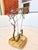 A bronze worked sculpture of a tree and children swinging at its base. The sculpture is mounted on a quartz base. A fun...