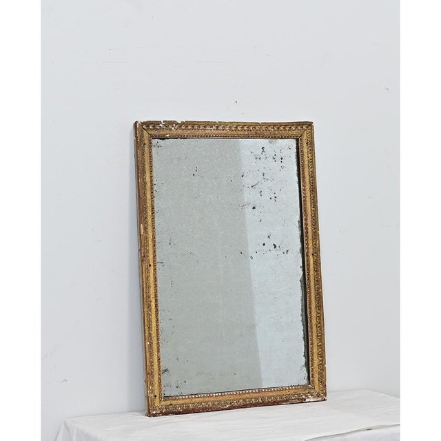 An exceptional French gilt mirror from the late 18th century retaining the original mirror glass. The heavily patinated...
