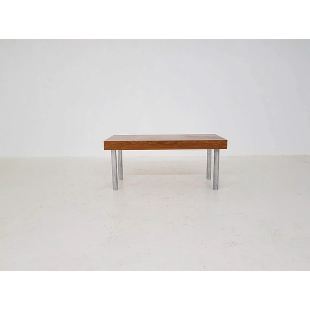 This piece has chrome feet and rosewood veneer top.