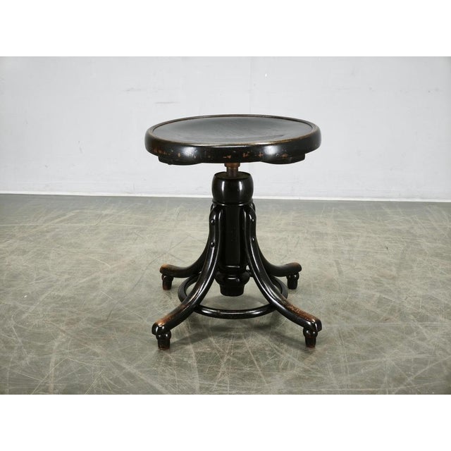 An elegant adjustable bentwood piano stool from Czechoslovakia, dating to the 1930s, featuring a sculptural black-finished...