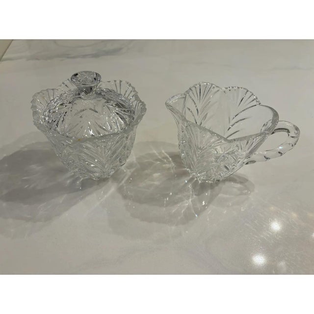 Offered is a vintage set of crystal creamer and sugar bowl set. This set features elegant cut glass with lid for the sugar...