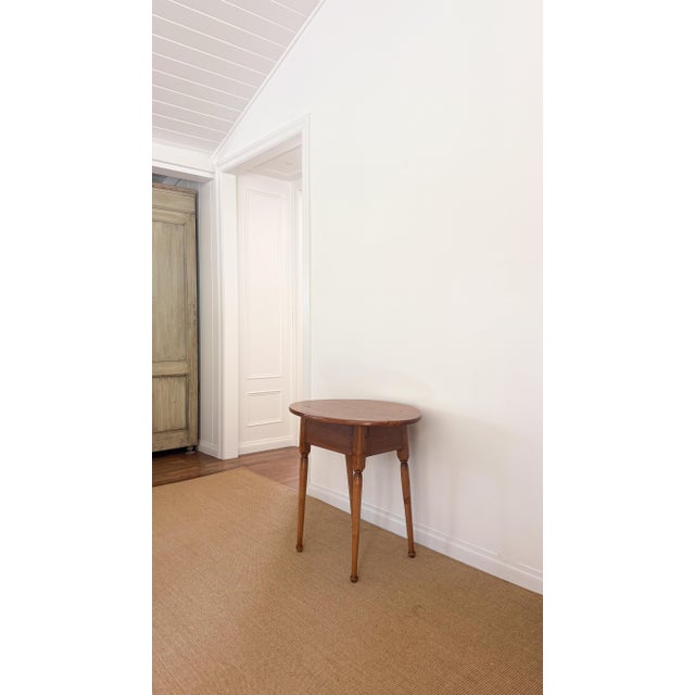 A 19th century oval tavern table with gracefully splayed legs, likely originating from New England.