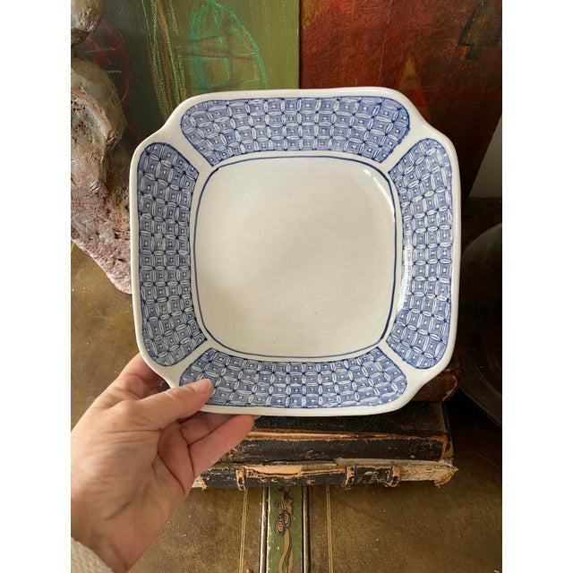 Pretty blue and white Asian bowl, presented in a mostly square shape with sides that gently slope and corners with just a...