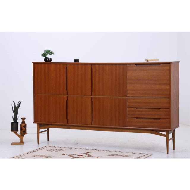 A large teak highboard with harmonious proportions and clean Danish lines. The combination of cabinet compartments,...