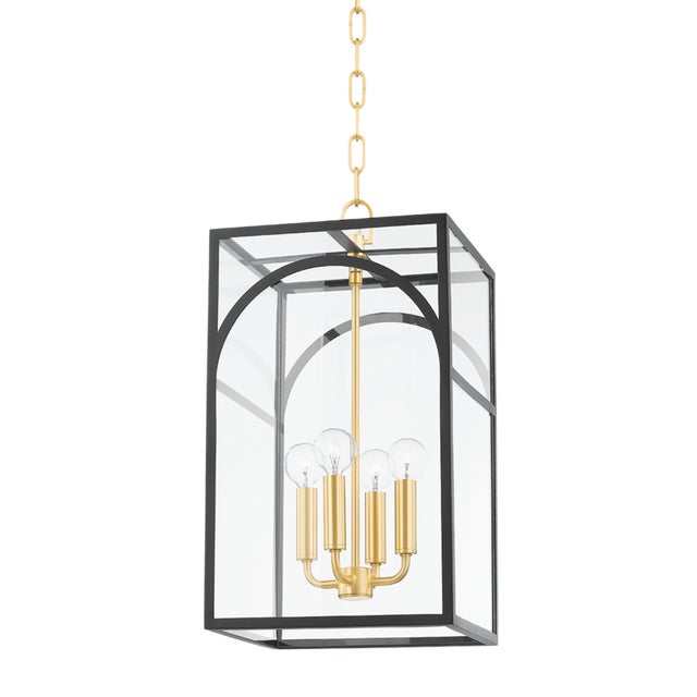 Like a fixture within a fixture, a series of aged brass candlesticks hang within a decorative metal cage. The arched...