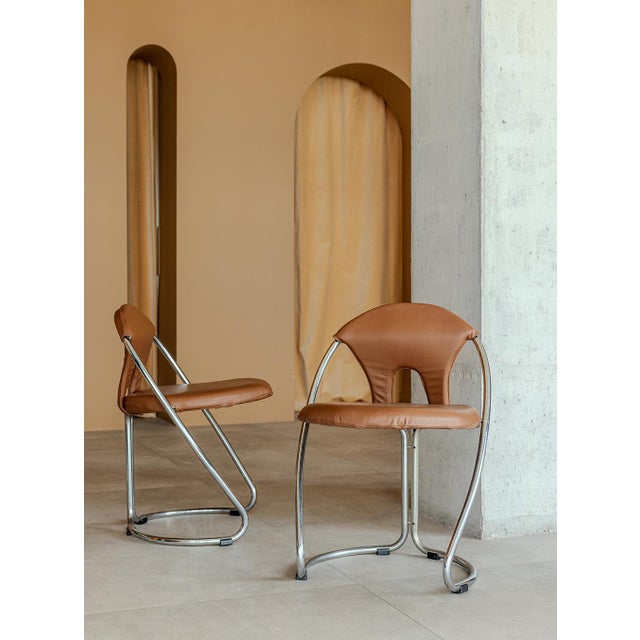 The chair features a gracefully curved tubular steel frame that creates a floating look. The organically shaped backrest,...