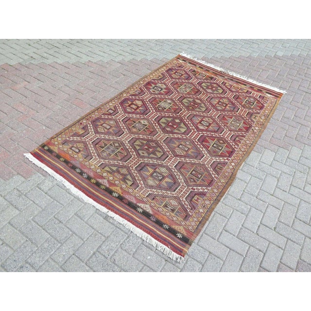 This beautiful, traditional vintage, flatweaved Turkish kilim rug is approximately 60 years old. It is handmade of very...