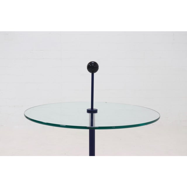 Post modern side table from the 1980s. The table is made from blue lacquered tubular steel and has a circular glass top...