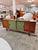 Original george coslin sideboard from the 1960s, made of rosewood with sliding doors upholstered in olive green fabric, a...