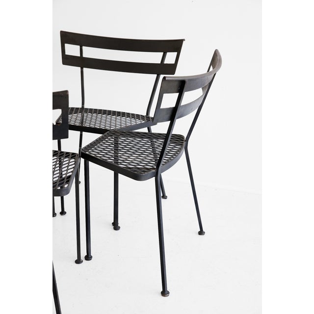 A well-composed set of four iron side chairs in the modernist garden furniture tradition, each constructed entirely in...