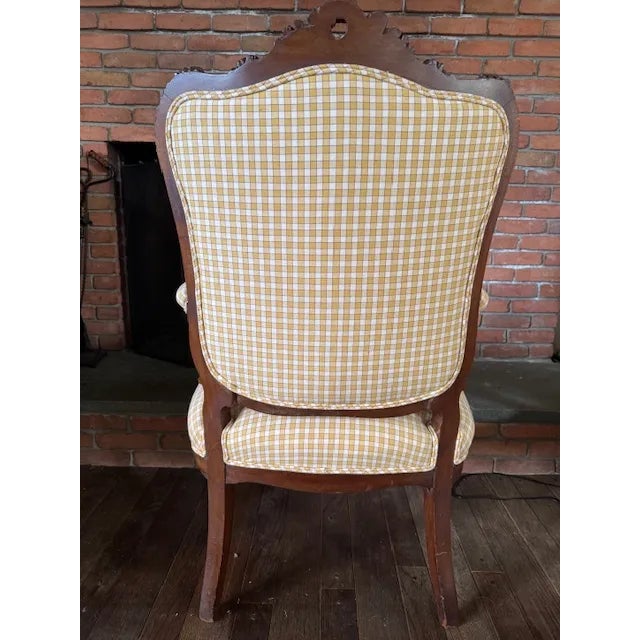 Graceful French Louis XV-style bergère chair, dating from the late 19th century (circa 1880–1900). The hand-carved walnut...