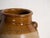This antique Chinese glazed stoneware vase is an ovoid jar with a caramel glaze with lug handles and stamped decoration of...