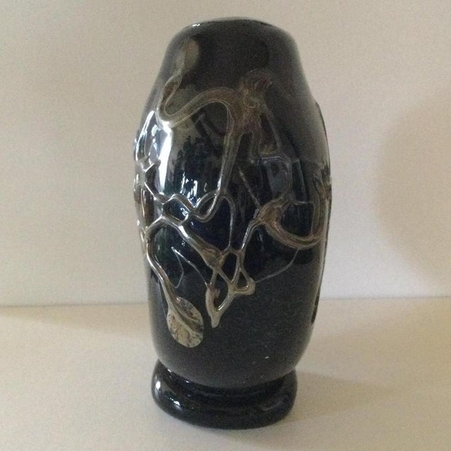 A three-layered, blown glass disc vase made of deep black glass paste, adorned with abstract motifs in hot-applied silver...