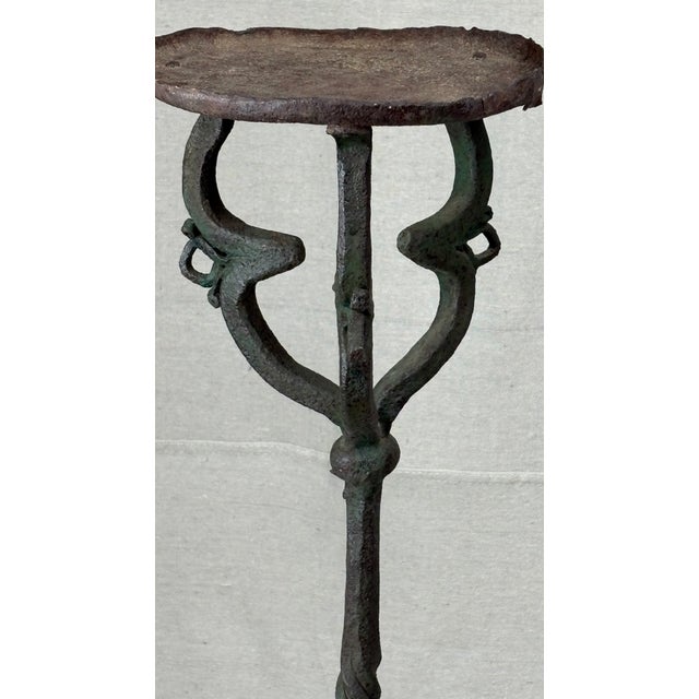 A sculptural wrought iron plant stand attributed to Samuel Yellin, showing the forge vocabulary and hand-worked detailing...