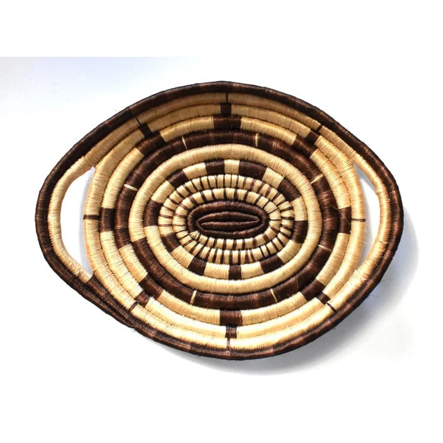 A vintage, mid-century woven coil basket tray in natural and dark brown, made by the Pima Papago / Tohono O'Odham Native...